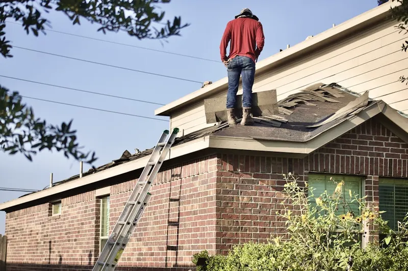 Professional roofer working on a residential roof in Closter